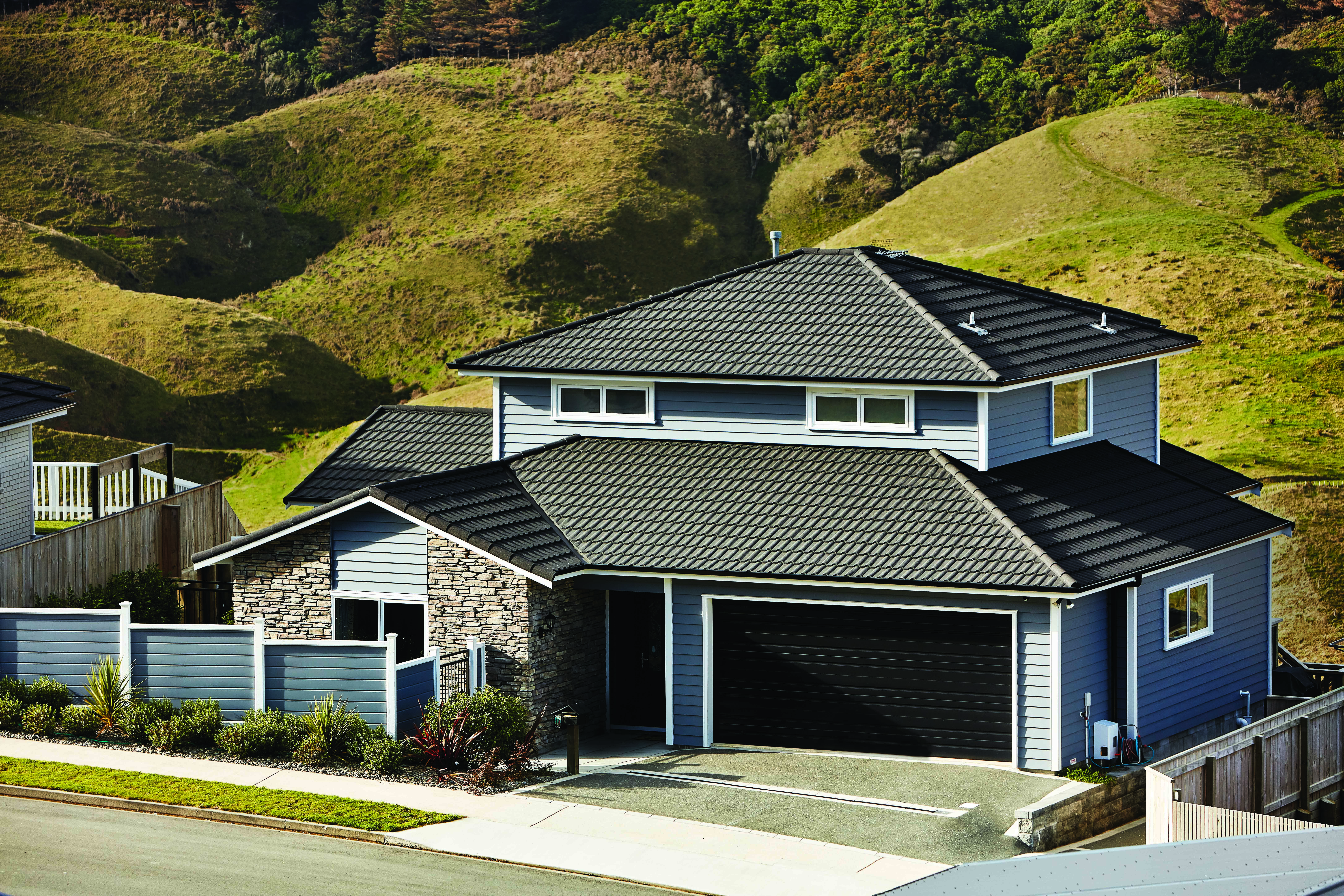 Gerard Milano steel tile roof with grassy hill in background